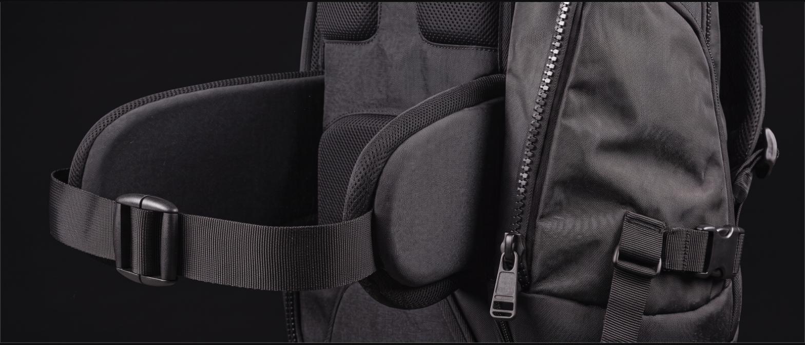 Close-up of a travel backpack shoulder harness, padded hip belt and heavy zipper